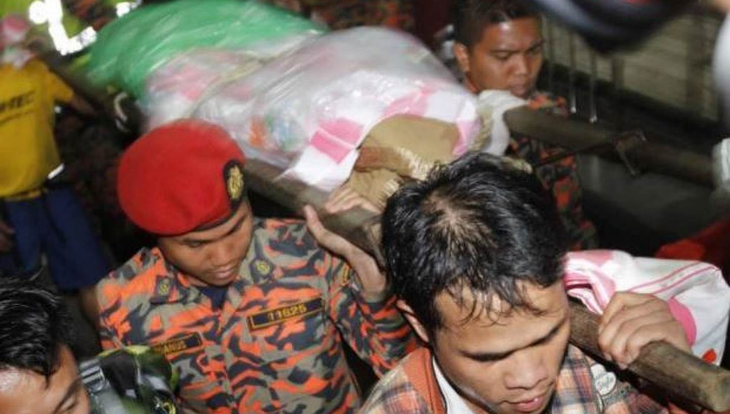 Rescue personnel bringing down a body to the foothill base camp at Timpohon gate in Kinabalu Park, Kundasang on Friday. -- PHOTO: THE STAR/ASIA NEWS NETWORK