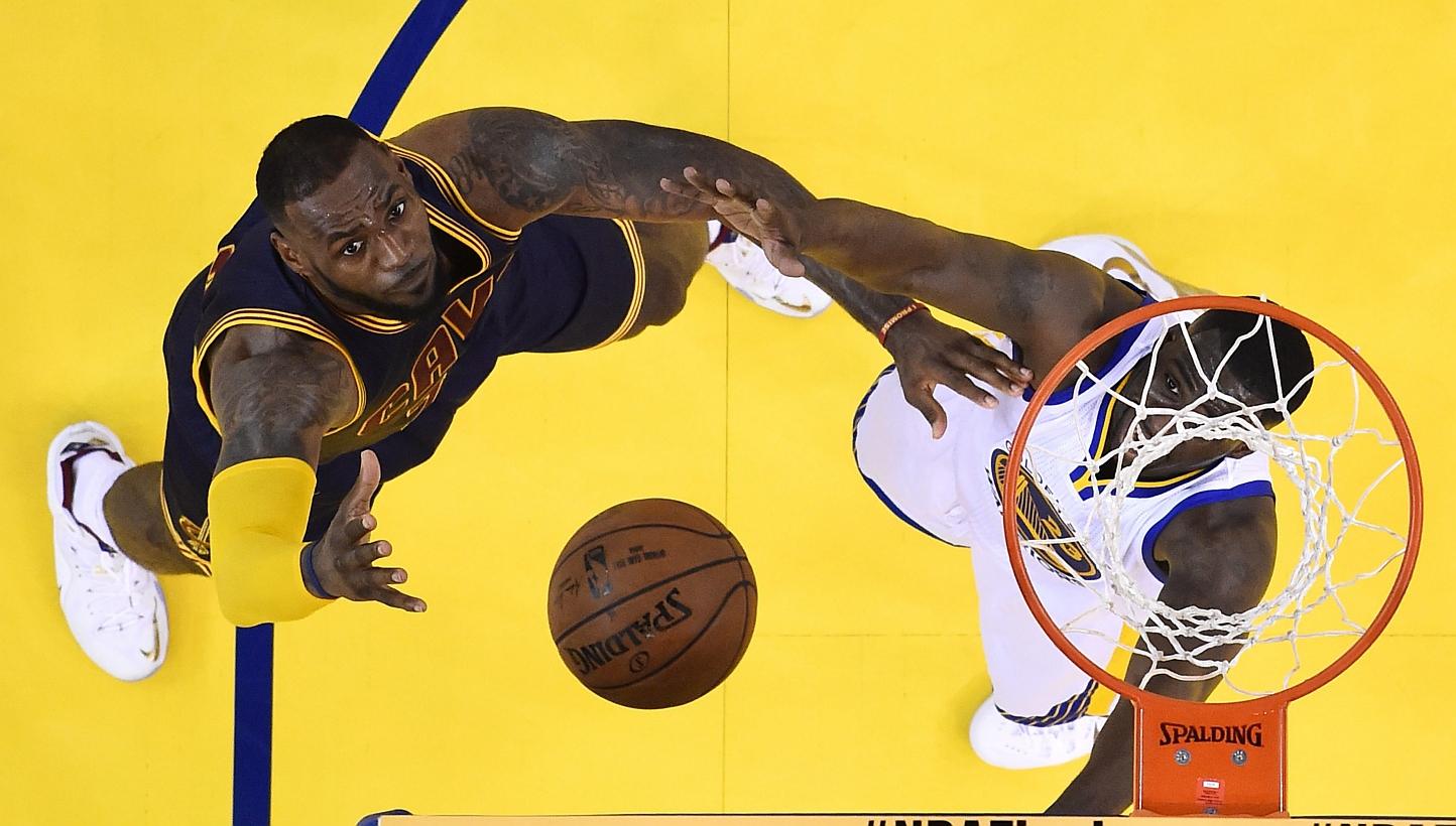 Cleveland Cavaliers player LeBron James (left) goes to the basket against Golden State Warriors player Draymond Green (right) in the first half of Game One of the NBA Finals at the Oracle Arena in Oakland, California on Thursday (June 4). -- PHOTO: E