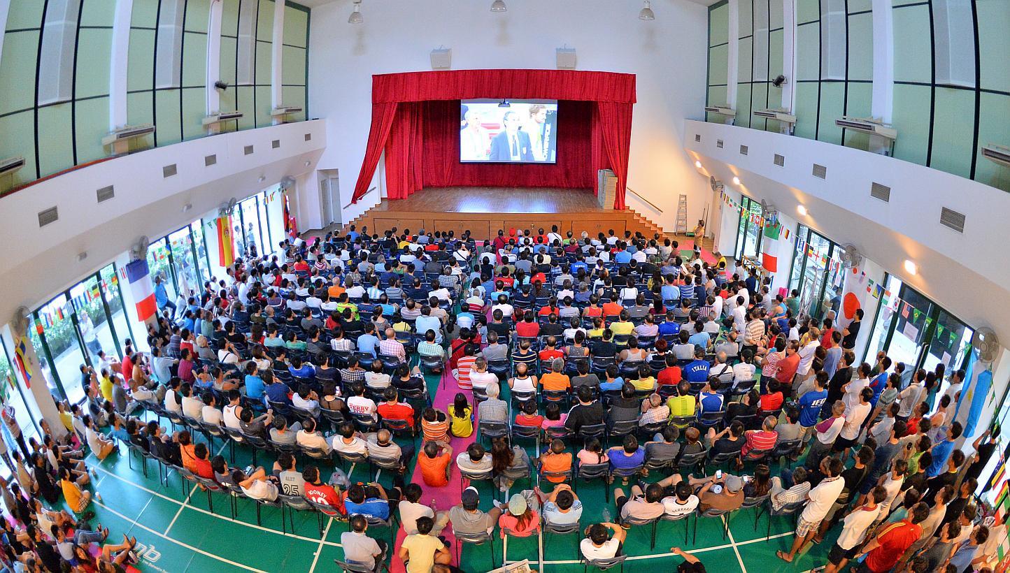 People at Bishan Community Club watching a World Cup football match in 2014. Selected CCs will be showing SEA Games events, including the opening ceremony on Friday evening, and live screenings of sports events, the People's Association said. -- PHOT