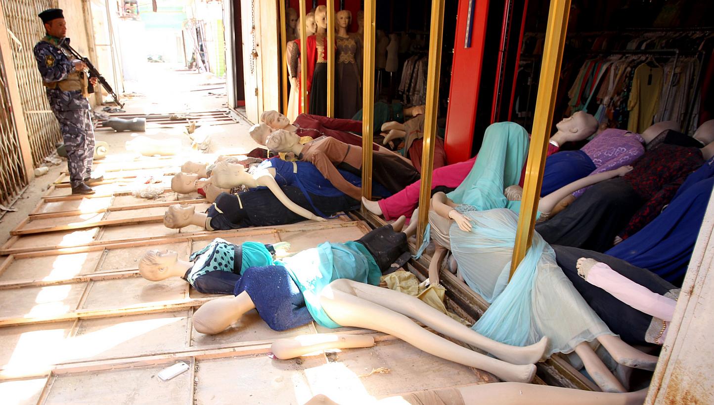 An Iraqi policeman looking at mannequins lying in front of a damaged shop in Tikrit on April 15, 2015. The International Monetary Fund said on Friday it was preparing US$833 million (S$1.1 billion) in emergency financial assistance to Iraq as the cou