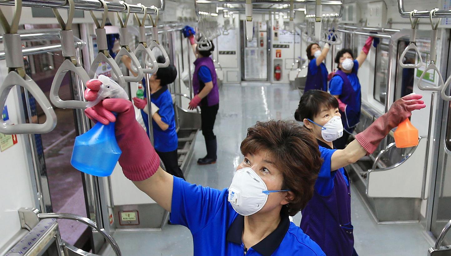Workers disinfecting a train carriage in Seoul on June 4, 2015. -- PHOTO: AFP