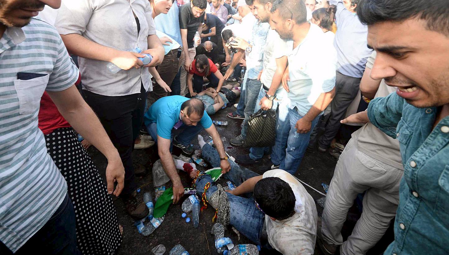 Injured people get first aid after an explosion during an election rally of the pro-Kurdish Peoples' Democratic Party (HDP) in Diyarbakir, Turkey, on June 5, 2015. Two people were killed and over 100 were injured when two explosions hit the rally, ju