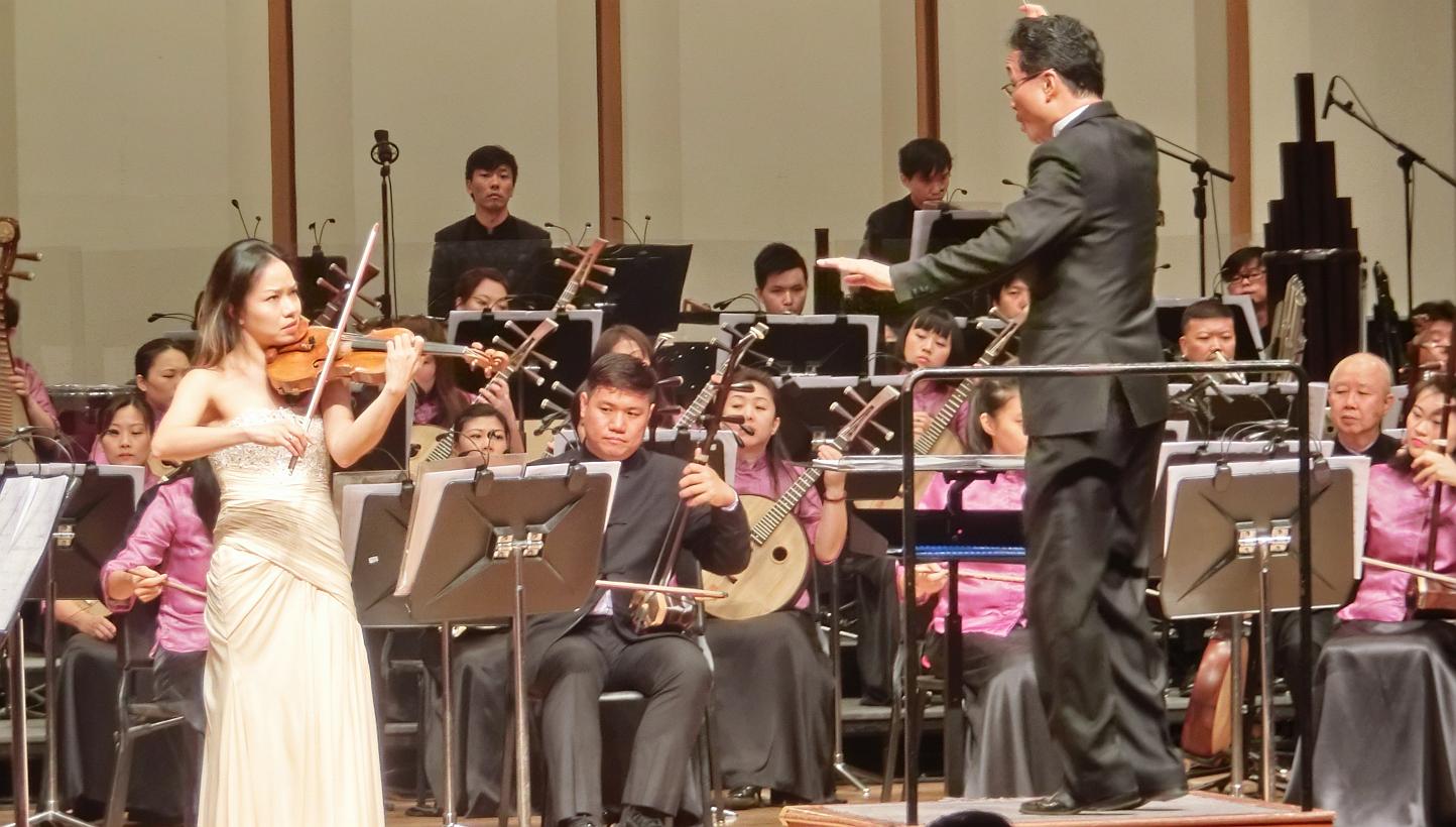 Violinist Kam Ning (left) performing with the Singapore Chinese Orchestra, conducted by Yeh Tsung. -- PHOTO: CHANG TOU LIANG
