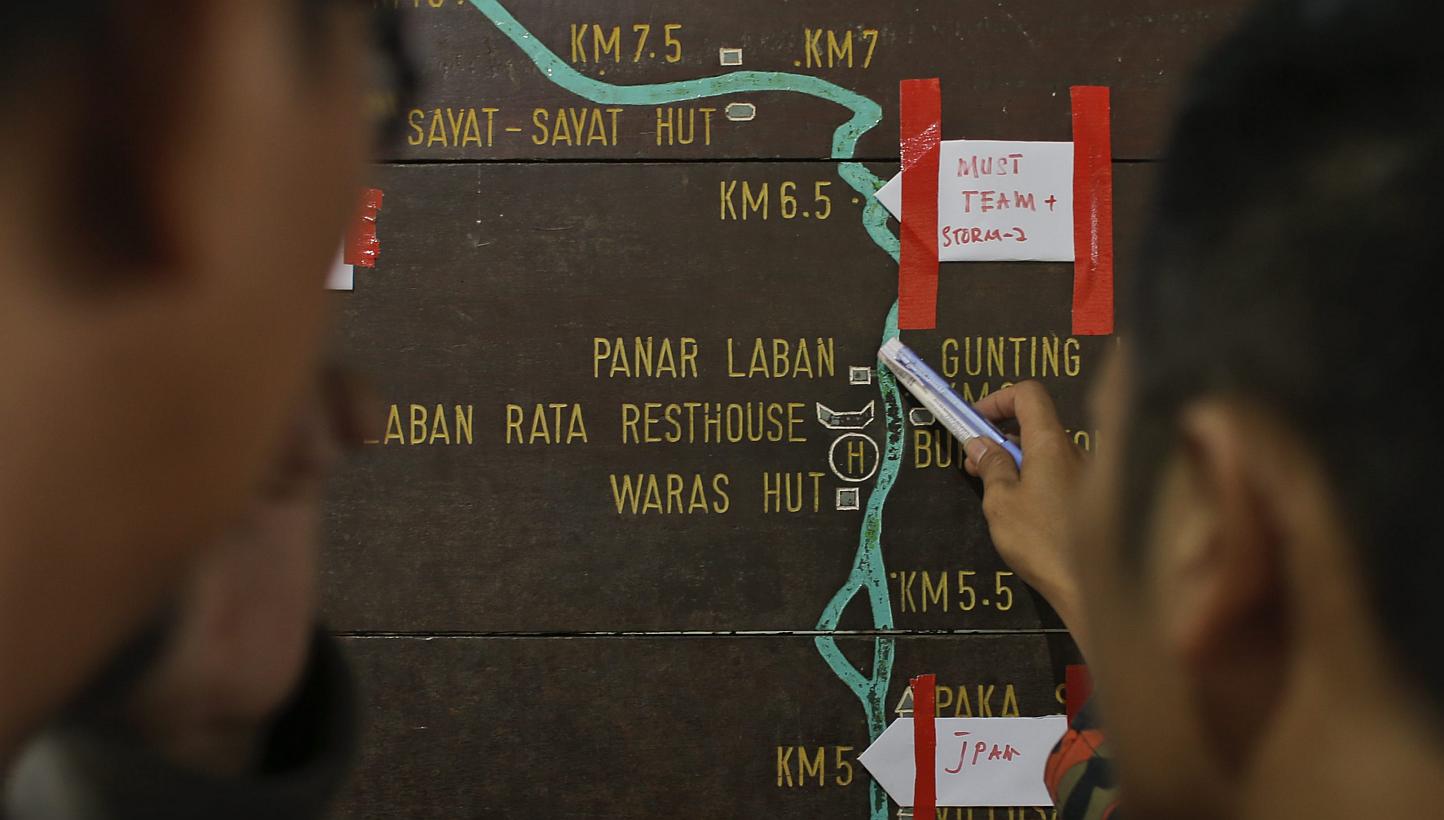 Malaysian rescue officials marking locations on an information board on the way to Mount Kinabalu during the rescue mission for more than 130 climbers stranded on one of South-east Asia's highest peaks after an earthquake rocked parts of Sabah, on Ju