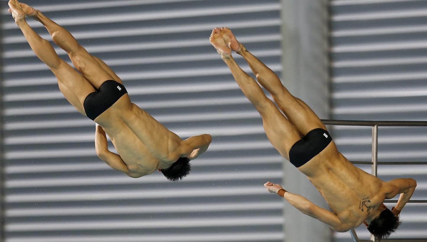 Malaysian divers Chew Yiwei (left) and Ooi Tze Liang (right) performing during the men's 10m synchronised platform final at the SEA Games in Singapore, on June 6, 2015. -- PHOTO: EPA