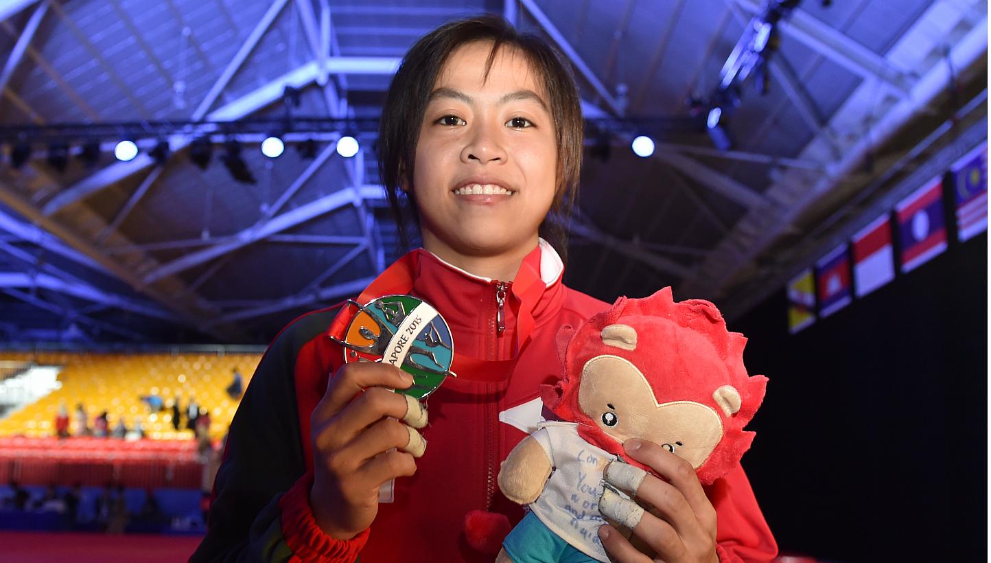 Judoka Ang Xuan Yi holding up the silver medal that she won in the women's 52-57kg event on June 6, 2015. -- ST PHOTO: CAROLINE CHIA&nbsp;