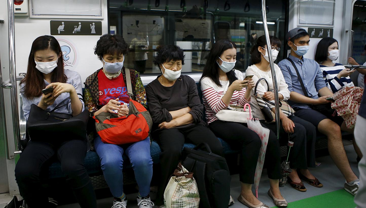 Passengers wearing masks to prevent contracting Middle East Respiratory Syndrome (MERS) sit inside a train in Seoul, South Korea, on June 5, 2015. -- PHOTO: REUTERS