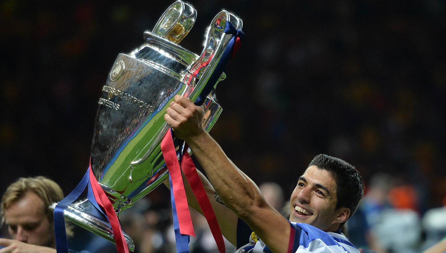 Barcelona's Uruguayan forward Luis Suarez celebrates with the trophy after the UEFA Champions League Final football match between Juventus and FC Barcelona at the Olympic Stadium in Berlin on June 6, 2015.&nbsp;
