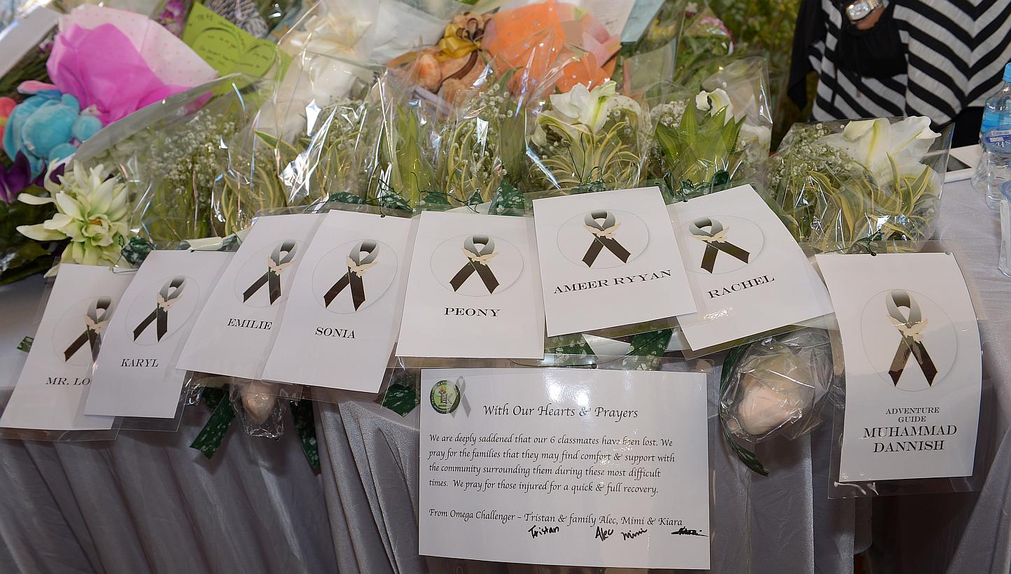 Bouquets of flowers in memory of the victims laid out on a table at Tanjong Katong Primary School. -- ST PHOTO: DESMOND WEE