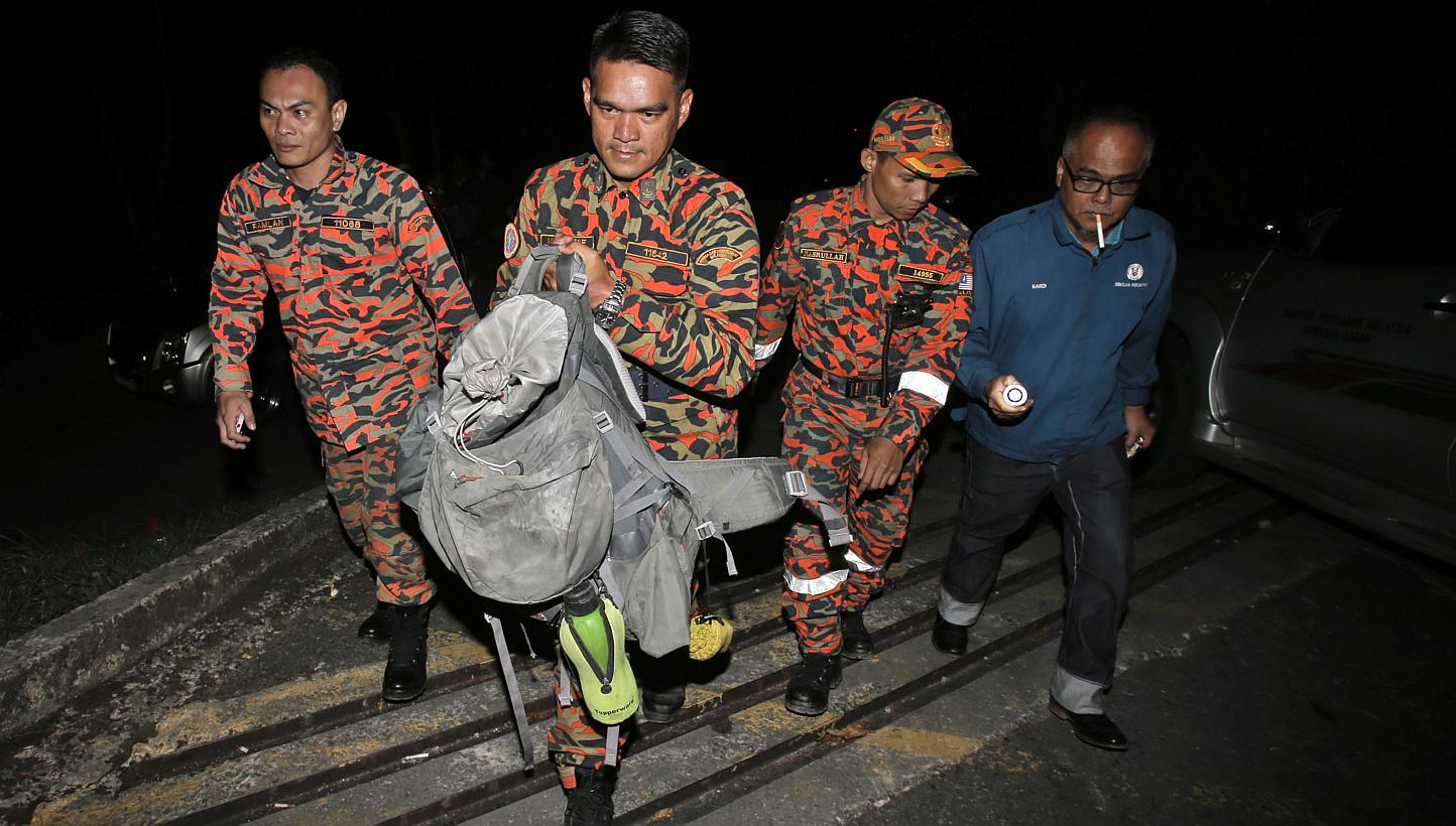 Members of a Malaysian Fire and Rescue Department team holding part of a body retreived from Mount Kinabalu on June 6, 2015. -- PHOTO: EPA