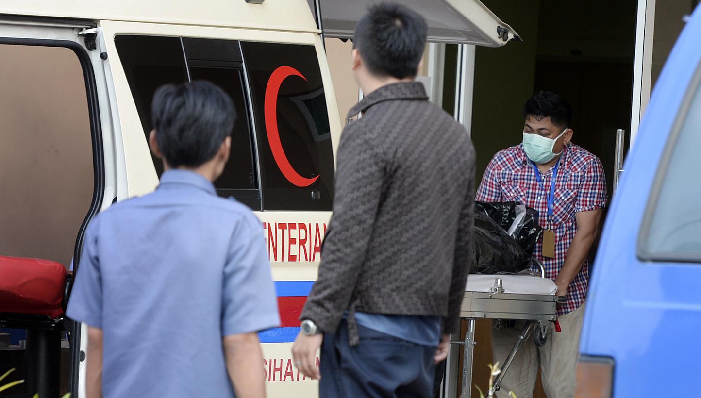 Personnel unload a body bag from an ambulance at the Mortuary at Queen Elizabeth Hospital at Kota Kinabalu on 6 June, 2015. Social and Family Development Minister Tan Chuan-Jin said those affected by the recent earthquake in Sabah should have s