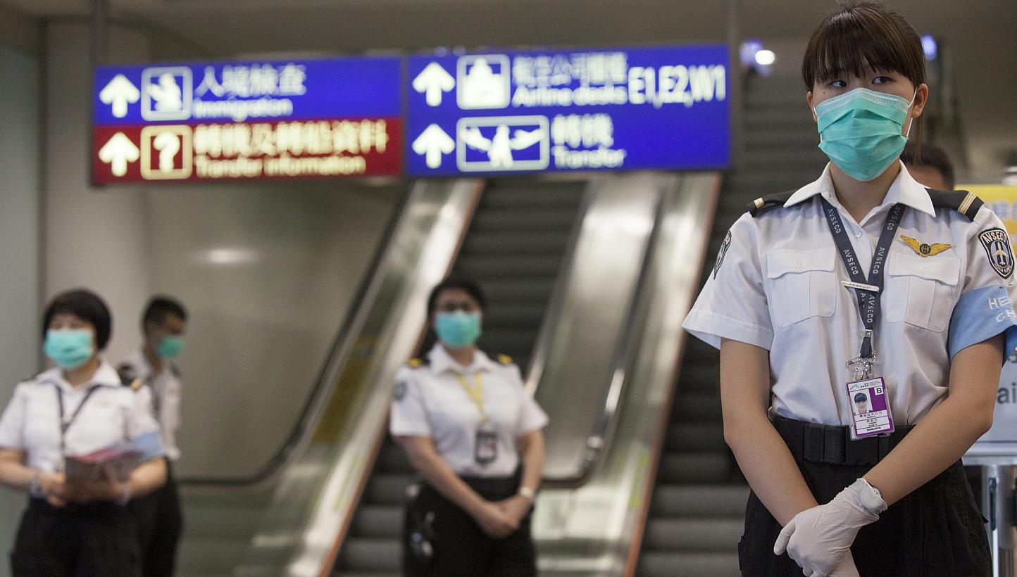 Health workers from Hong Kong's Department of Health are seen prior to checking passengers arriving for Middle East Respiratory Syndrome (MERS), at Hong Kong International Airport, Hong Kong, China, on June 5, 2015. -- PHOTO: EPA