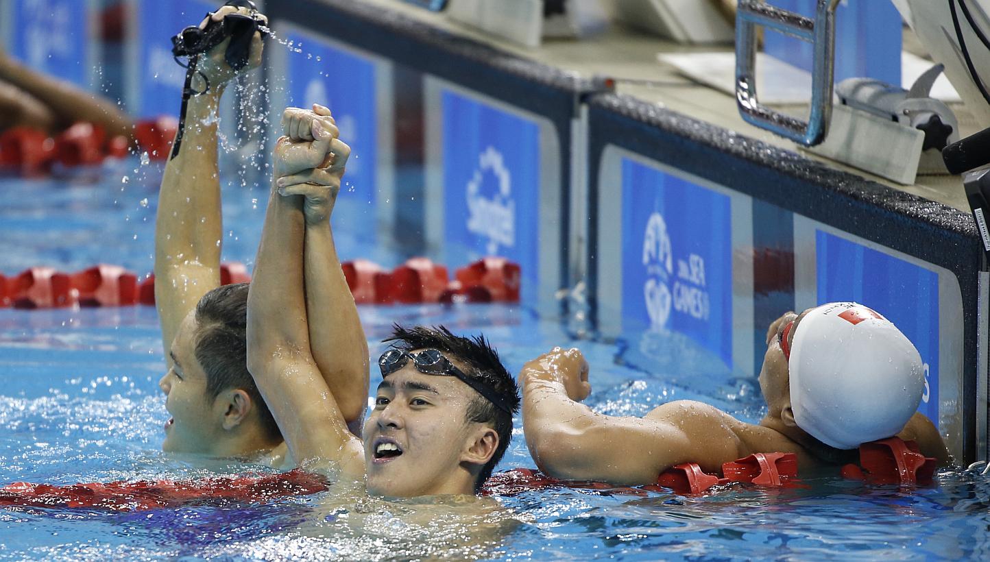 Swimmer Quah Zheng Wen (centre) raising his right hand in triumph with teammate Pang Sheng Jun (left) after winning the 400m individual medley on June 9, 2015. It was Singapore's 51st gold medal of the SEA Games, breaking the previous mark of 50 set 