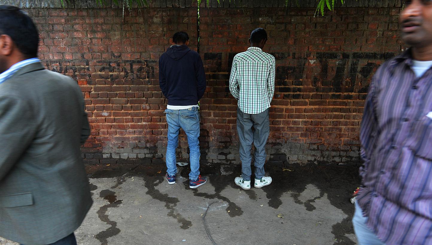 In this photograph taken on Nov 18, 2014, Indian men urinate on a wall at the roadside in New Delhi, the eve of World Toilet Day. A city council in western India is planning to pay residents to use public toilets in a desperate attempt to stop legion