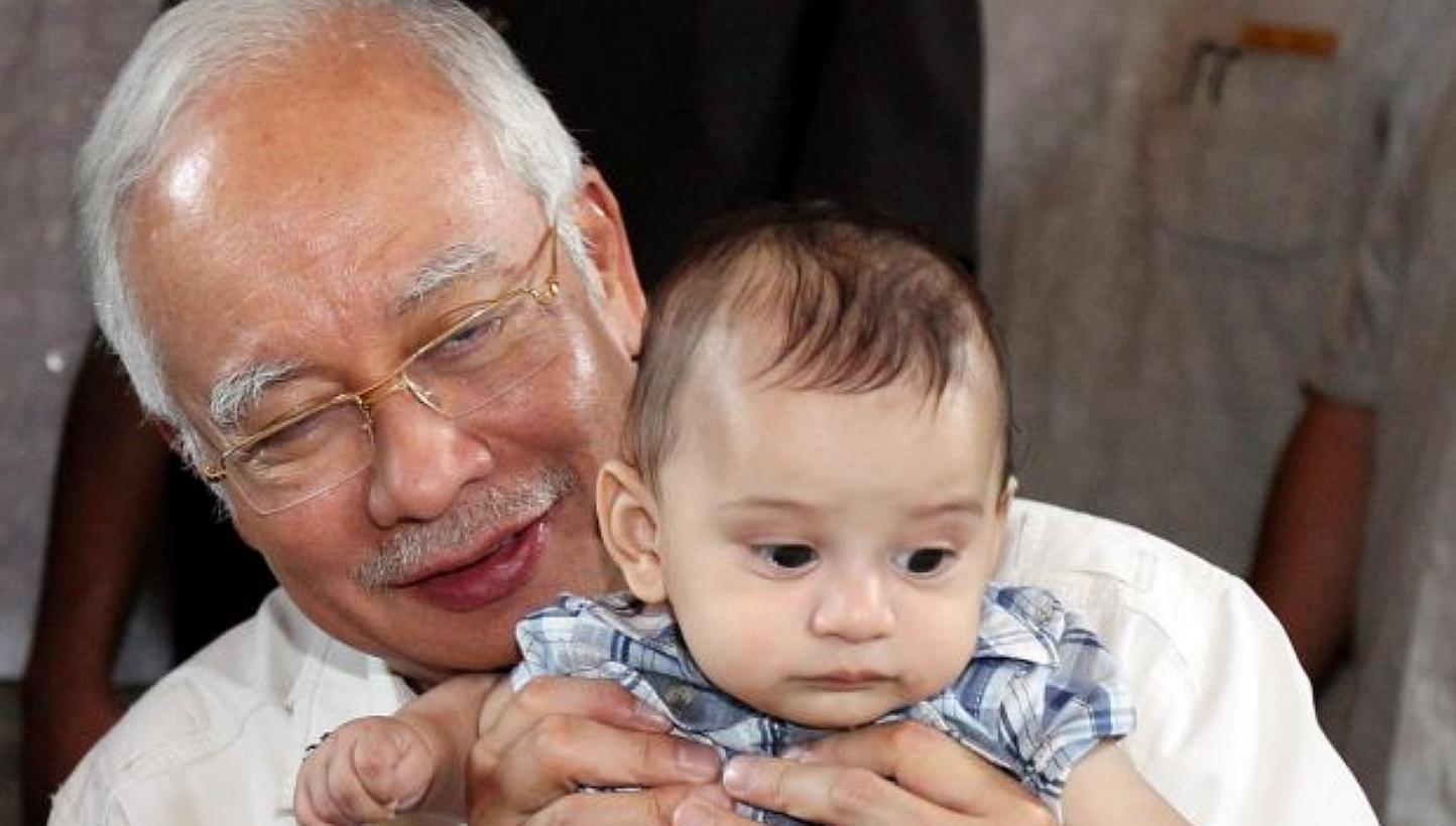 Datuk Seri Najib Tun Razak holding Camaron Robbi, son of the late Robbi Sapinggi, during a visit to Mount Kinabalu. -- PHOTO: THE STAR/ ASIA NEWS NETWORK&nbsp;