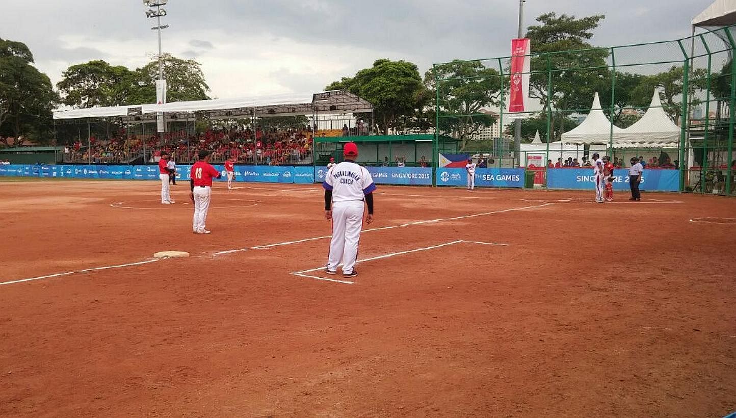 Singapore's men's softball team (in red) taking on the Philippines in their SEA Games semi-final match at the Kallang Softball Field on June 9, 2015. -- ST PHOTO: CHARLES ONG&nbsp;