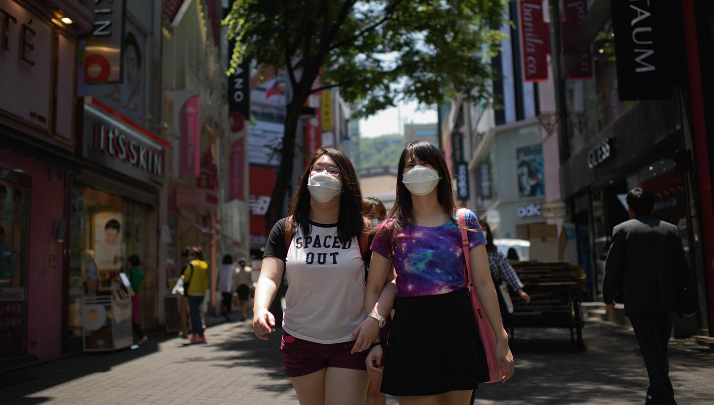 Tourists wearing face masks walk in the popular Myeongdong shopping area in Seoul on June 4, 2015.&nbsp;Taiwanese health authorities issued a travel alert to cover all of South Korea late on Tuesday, widening its caution on travel to the country stri