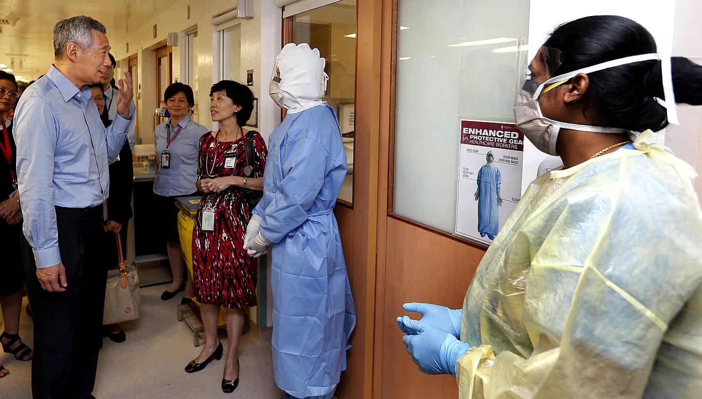 (From left) Prime Minister Lee Hsien Loong with senior consultant Brenda Ang, and nurses Felicia Tang and Sujithra Nair at Tan Tock Seng Hospital, which is Singapore's designated isolation centre for suspected and confirmed Mers patients. -- ST PHOTO