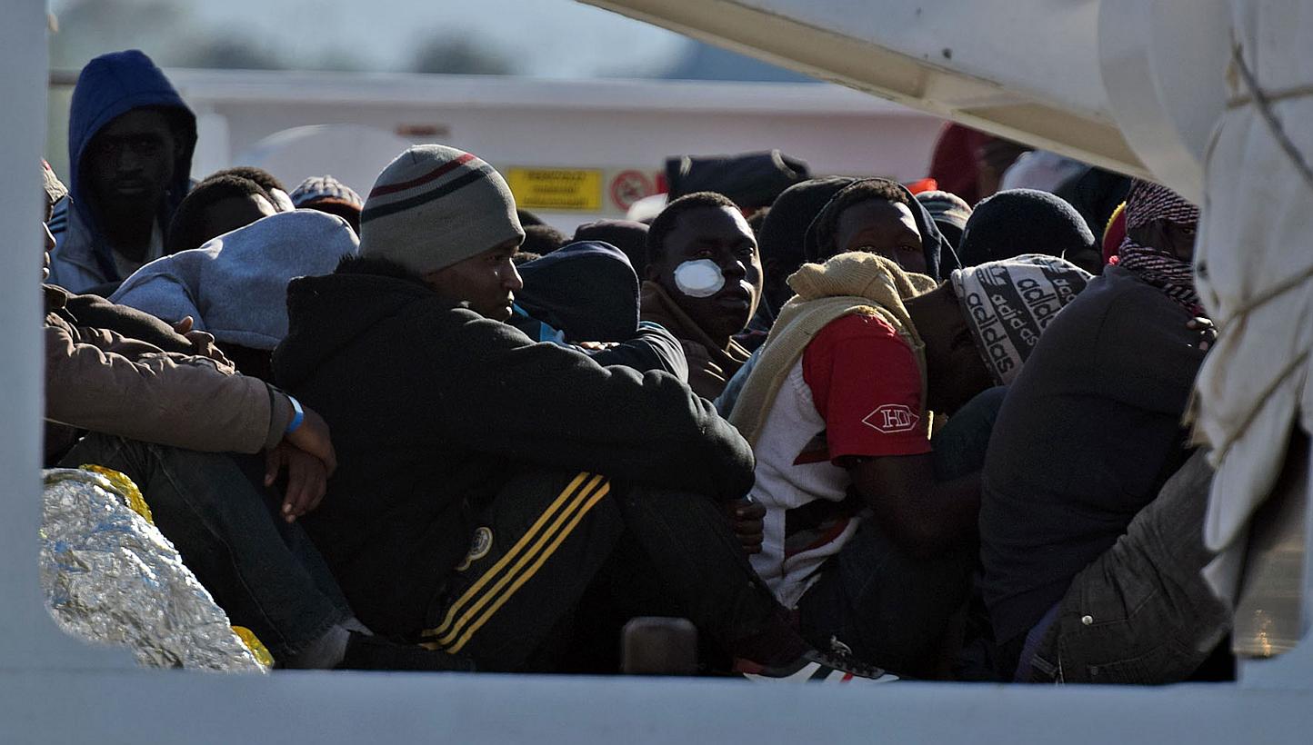 Shipwrecked migrants sitting on the deck of a rescue vessel as they arrived in the Italian port of Augusta in Sicily in April. A market in which states can buy and sell all or part of their protection quota obligations should be created, suggests the