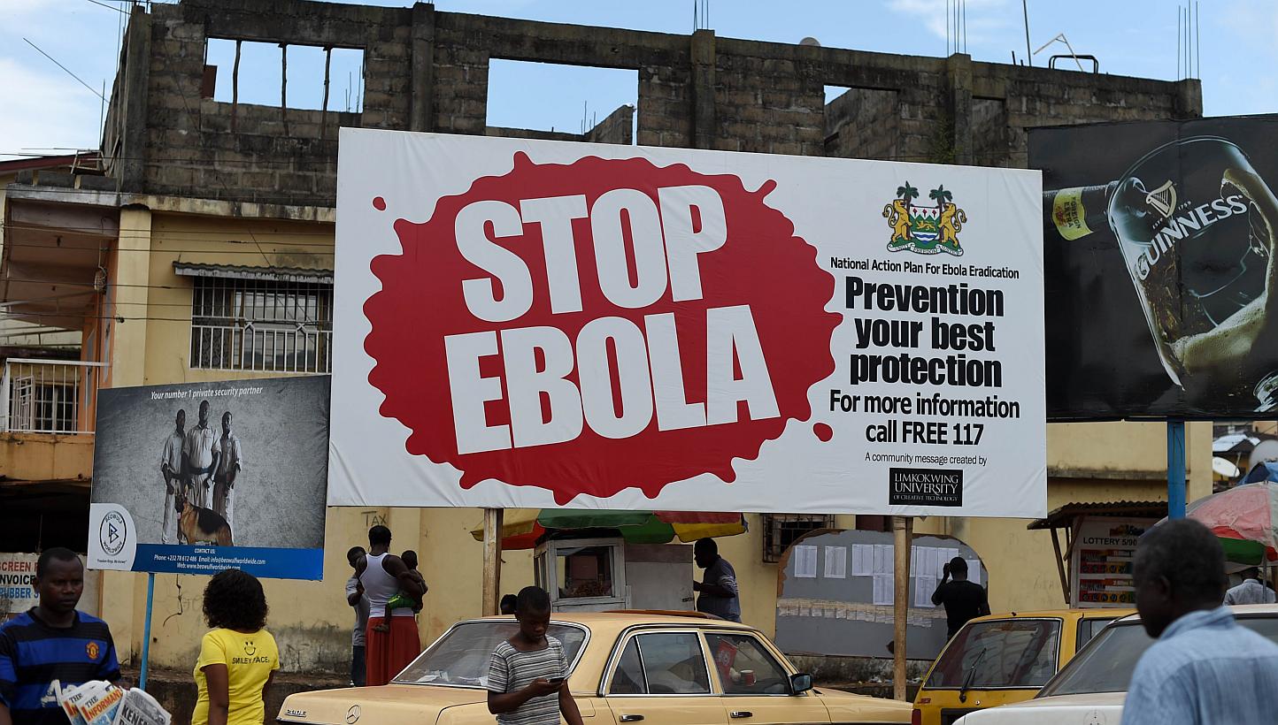 People walking pass a billboard on Ebola in Freetown, Sierra Leone, on Nov 7, 2014. The World Health Organisation on Wendesday, June 10, 2015, reported that the number of Ebola cases in Sierra Leone and Guinea has risen for the second consecutive wee