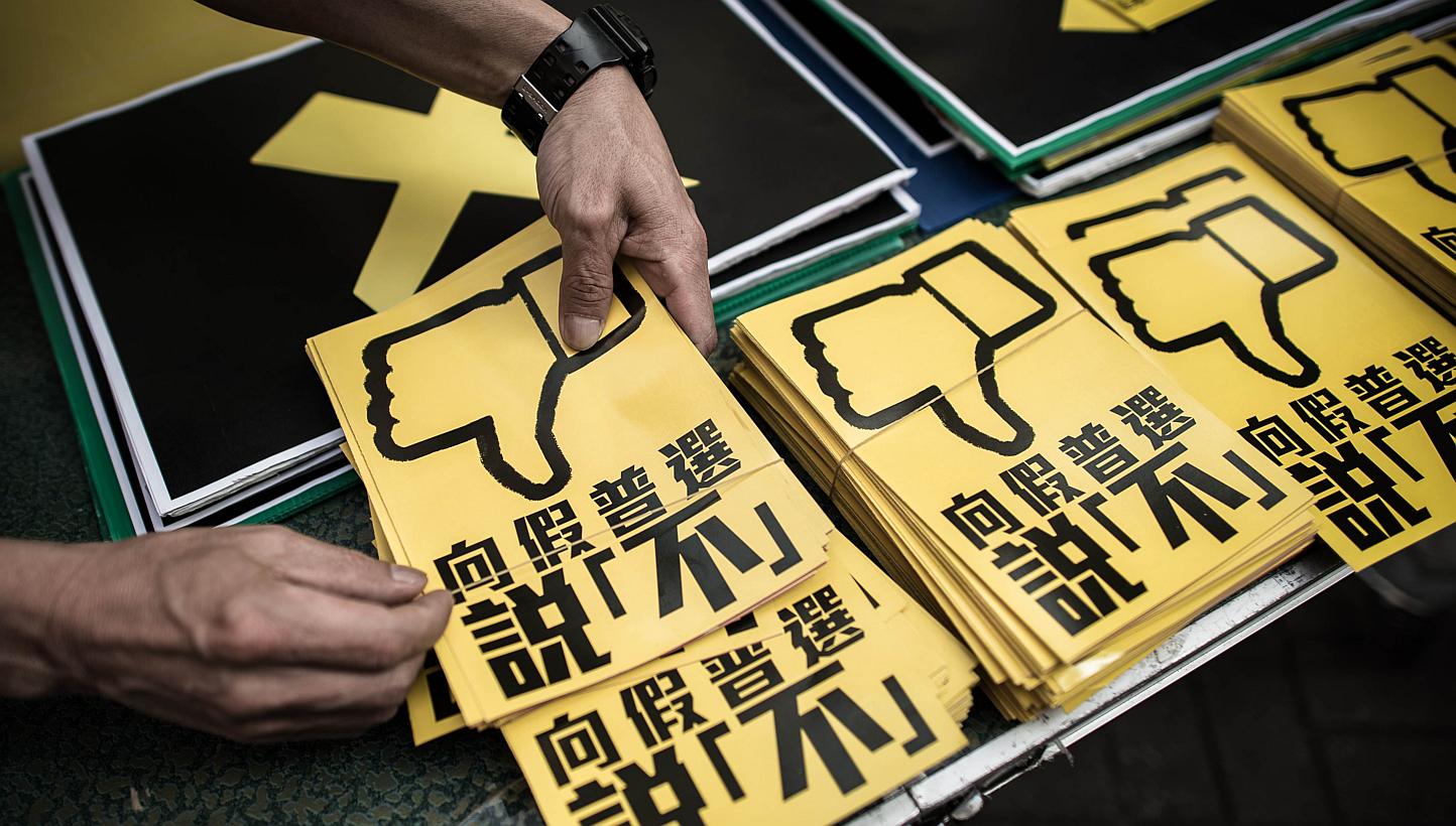 In this picture taken on April 26, 2015 in Hong Kong, a pan-democrat arranges leaflets against the government's controversial leadership election roadmap which sticks to a ruling from Beijing that all candidates should be vetted before a public vote 