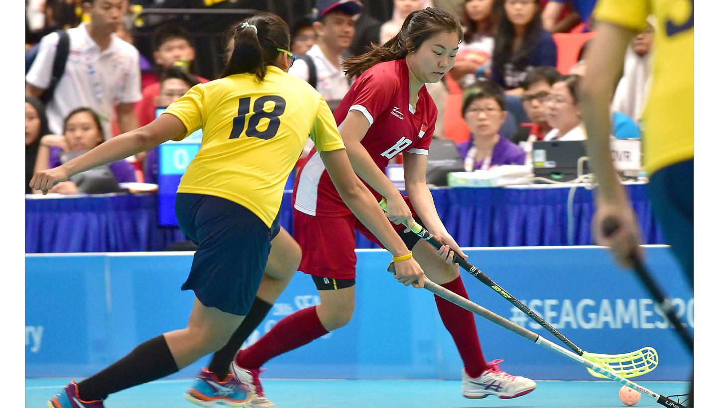 Singapore and Malaysia women's floorball teams in action at ITE College Central on June 11, 2015. Singapore's floorball teams are off to a flying start on the opening day of the SEA Games competition on Thursday, with both men and women chalking up b