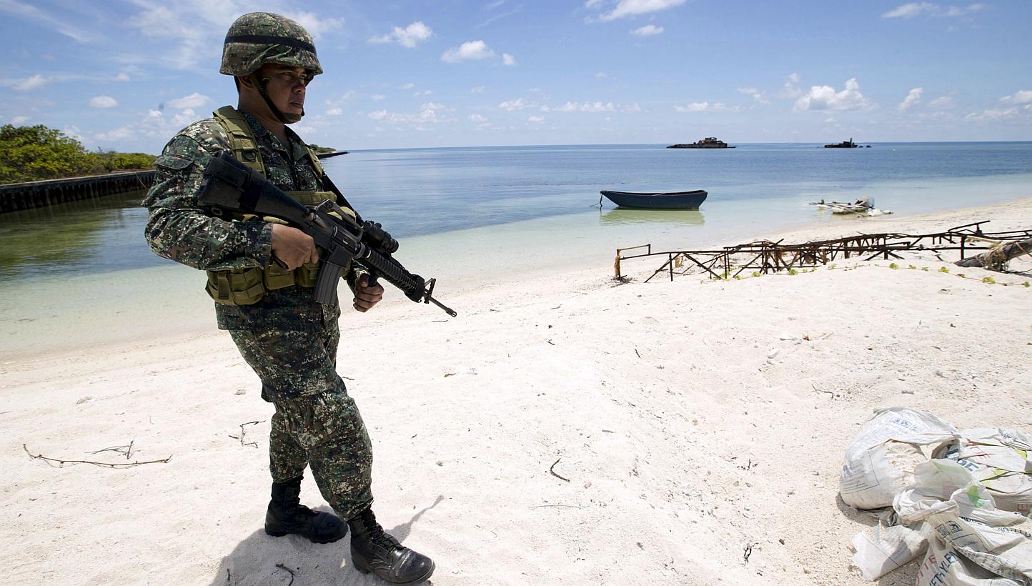 A Filipino soldier patrols the shore of Pagasa island (Thitu Island) in the Spratly group of islands in the South China Sea, west of Palawan, Philippines, in this May 11, 2015 file photo. -- PHOTO: REUTERS 