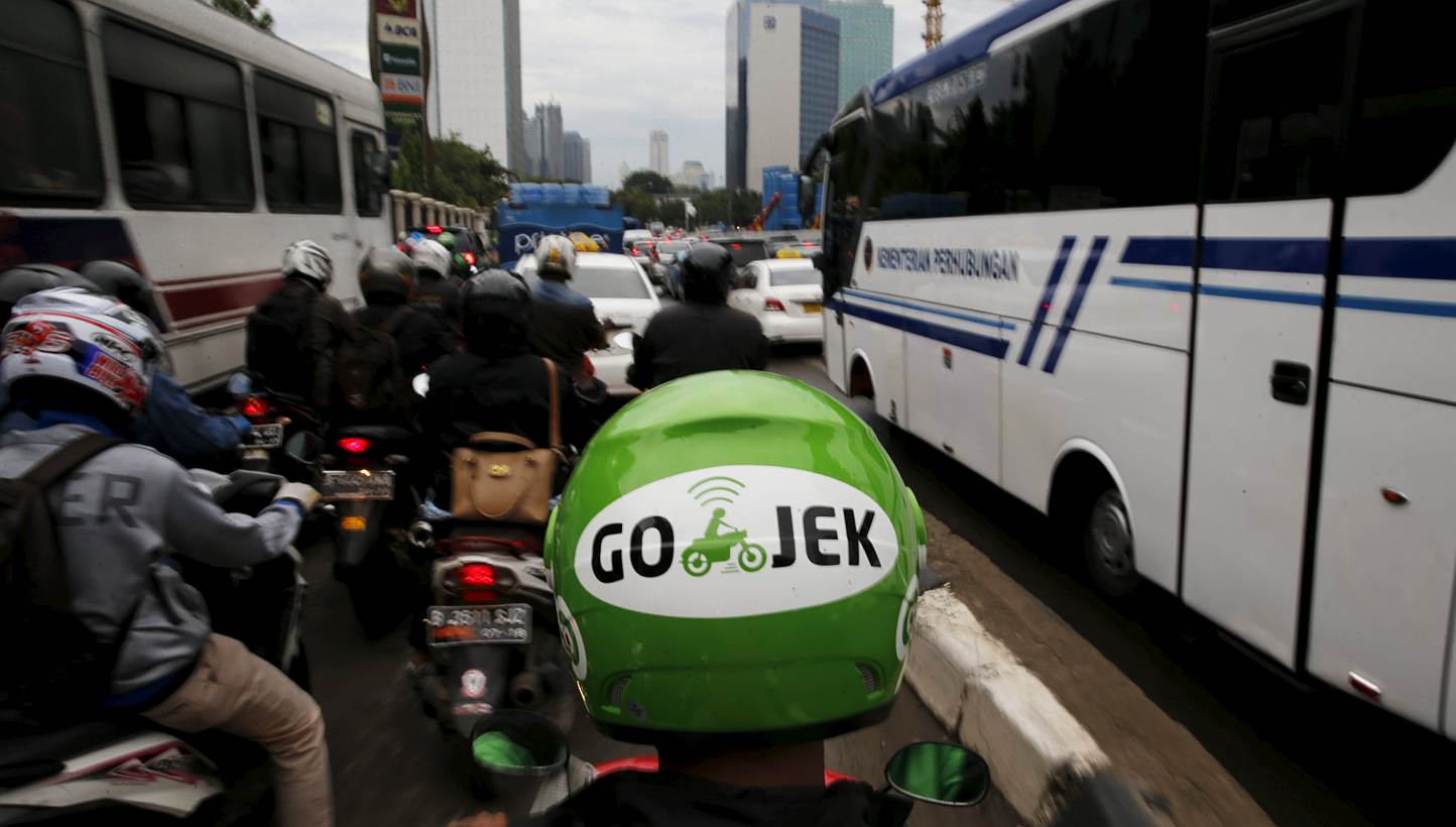 A GO-JEK driver rides his motorcycle through a business district street in Jakarta on June 9, 2015. Jakarta's traffic jams are a constant vexation for the city's 10 million residents but the Indonesian capital's glaring inefficiencies have also creat