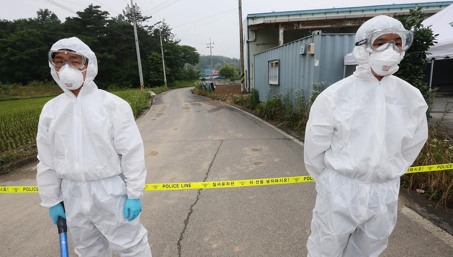 Health workers in protective suits standing by a quarantined village in Boseong, at the tip of the South Korean peninsula, on June 11, 2015. -- PHOTO: AFP
