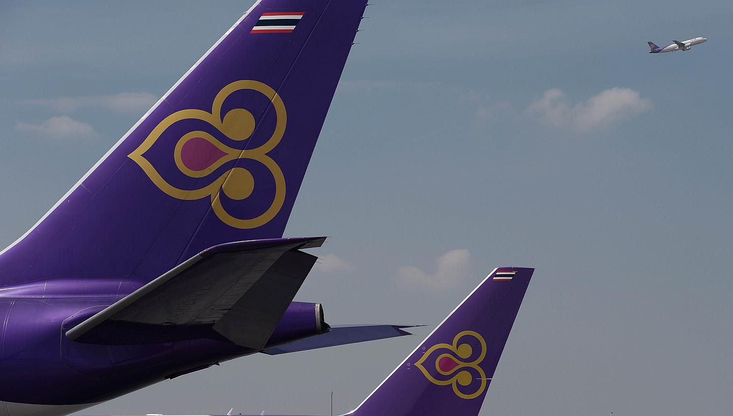 A Thai Airways aircraft takes off past the tails of two other Thai Airways planes at Bangkok's Suvarnabhumi international airport in a November 2014 file photo. Authorities at Lahore airport in Pakistan arrested four men suspected of trying to s