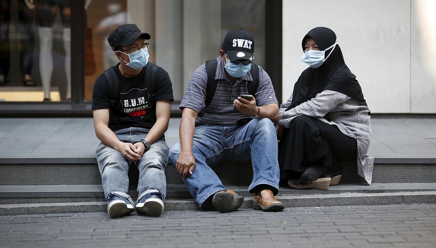 Tourists wearing masks to prevent contracting Mers resting at Myeongdong shopping district in central Seoul on June 12, 2015. -- PHOTO: REUTERS