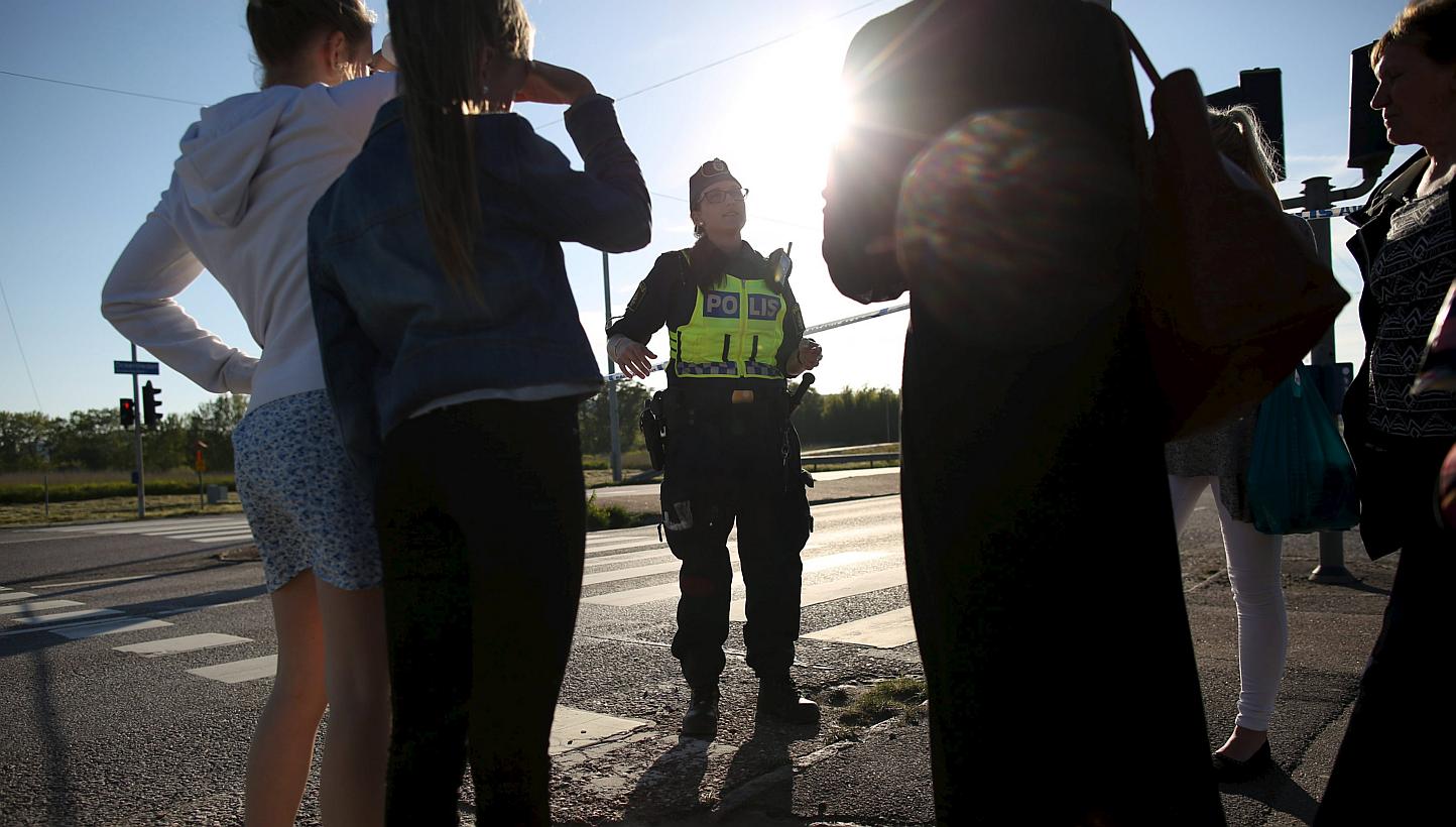 A police officer speaks to eyewitnesses after a car exploded (not pictured) at a roundabout in Gothenburg on June 12, 2015. -- PHOTO: REUTERS