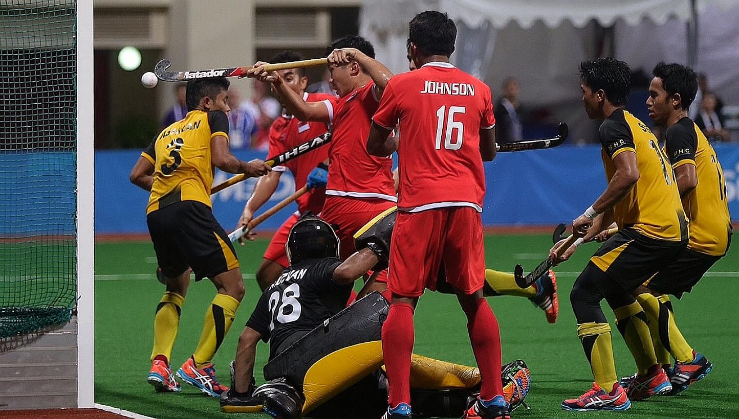 Singapore scoring a goal against Malaysia in the men's hockey final at the Sengkang Hockey Stadium on June 13, 2015. -- ST PHOTO: NEO XIAOBIN