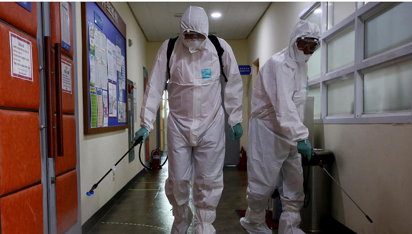A Seoul metropolitan government worker wearing a protective suit spraying antiseptic solution inside a hallway at the Sowol Art Hall in Seoul on June 12, 2015. -- PHOTO: BLOOMBERG