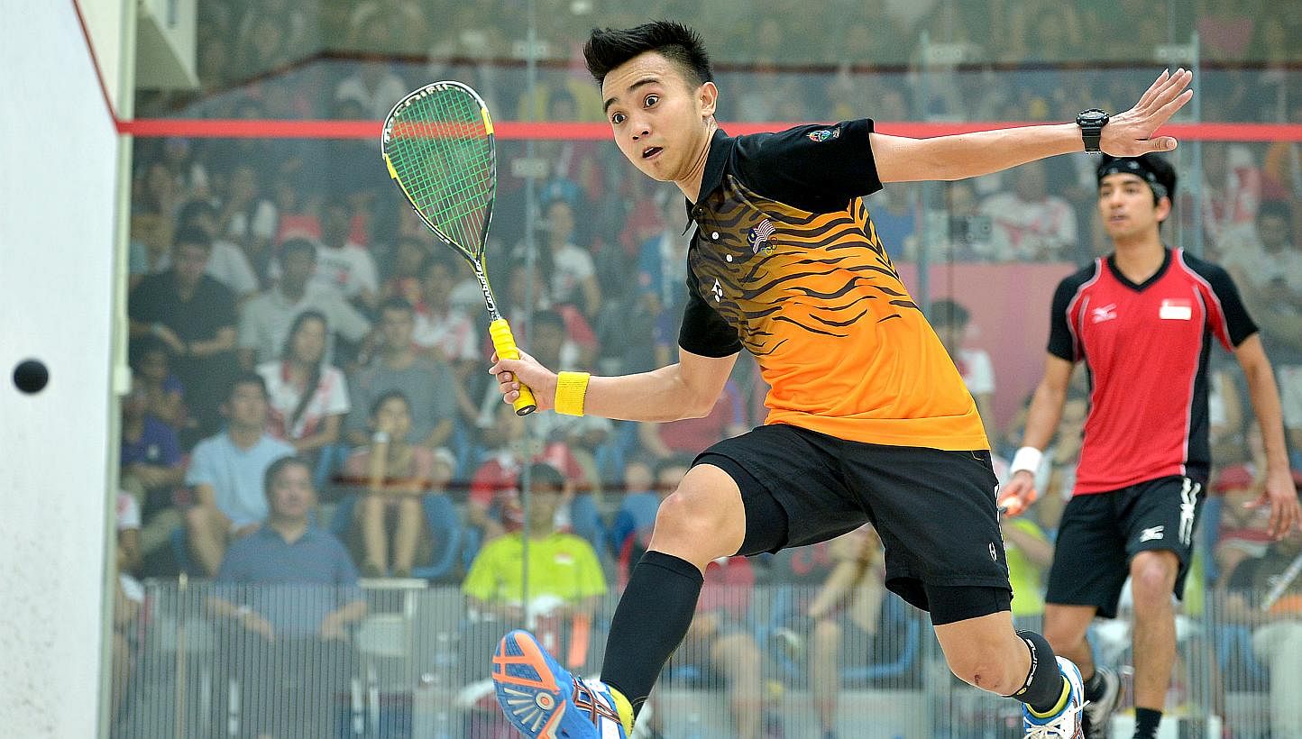 Malaysia's Muhd A. Bahtiar goes for the ball as he plays against Singapore's Samuel Kang.&nbsp;Singapore had to settle for the SEA Games squash men's team silver after losing the final 0-2 to Malaysia on Saturday, June 13, 2015. -- ST PHOTO:&nbsp;KUA
