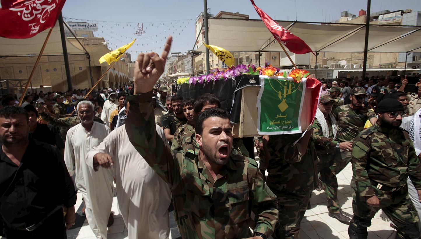Mourners carry the coffin of a fighter from the Iraqi Shi'ite Badr Organization, who was killed in clashes with Islamic State militants in Baiji, during a funeral in Najaf, south of Baghdad, June 13, 2015. -- PHOTO: REUTERS