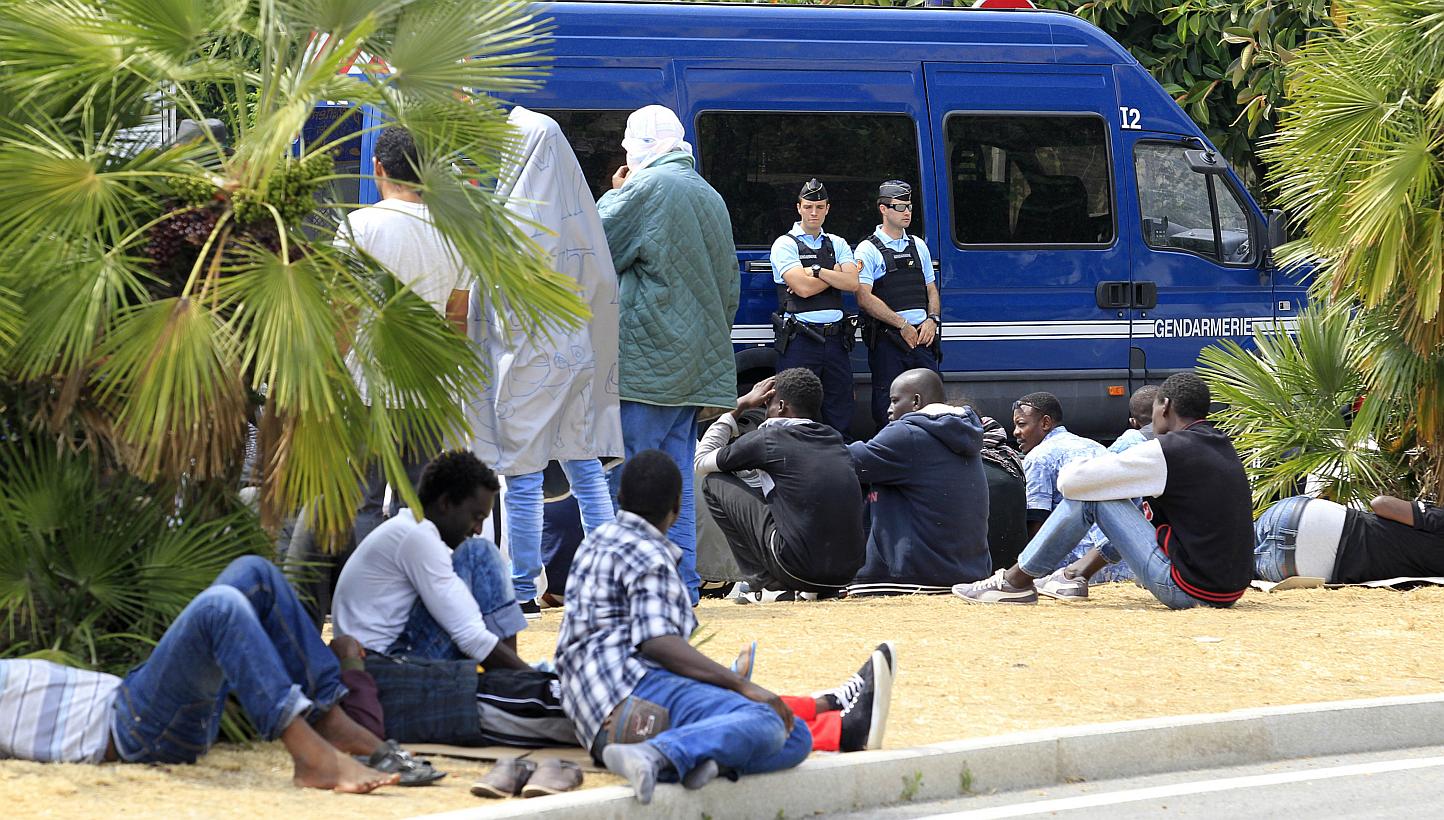 Migrants waiting face French gendarmes at the border between Italy and France in the city of Ventimiglia, Italy, on June 13, 2015. -- PHOTO: AFP