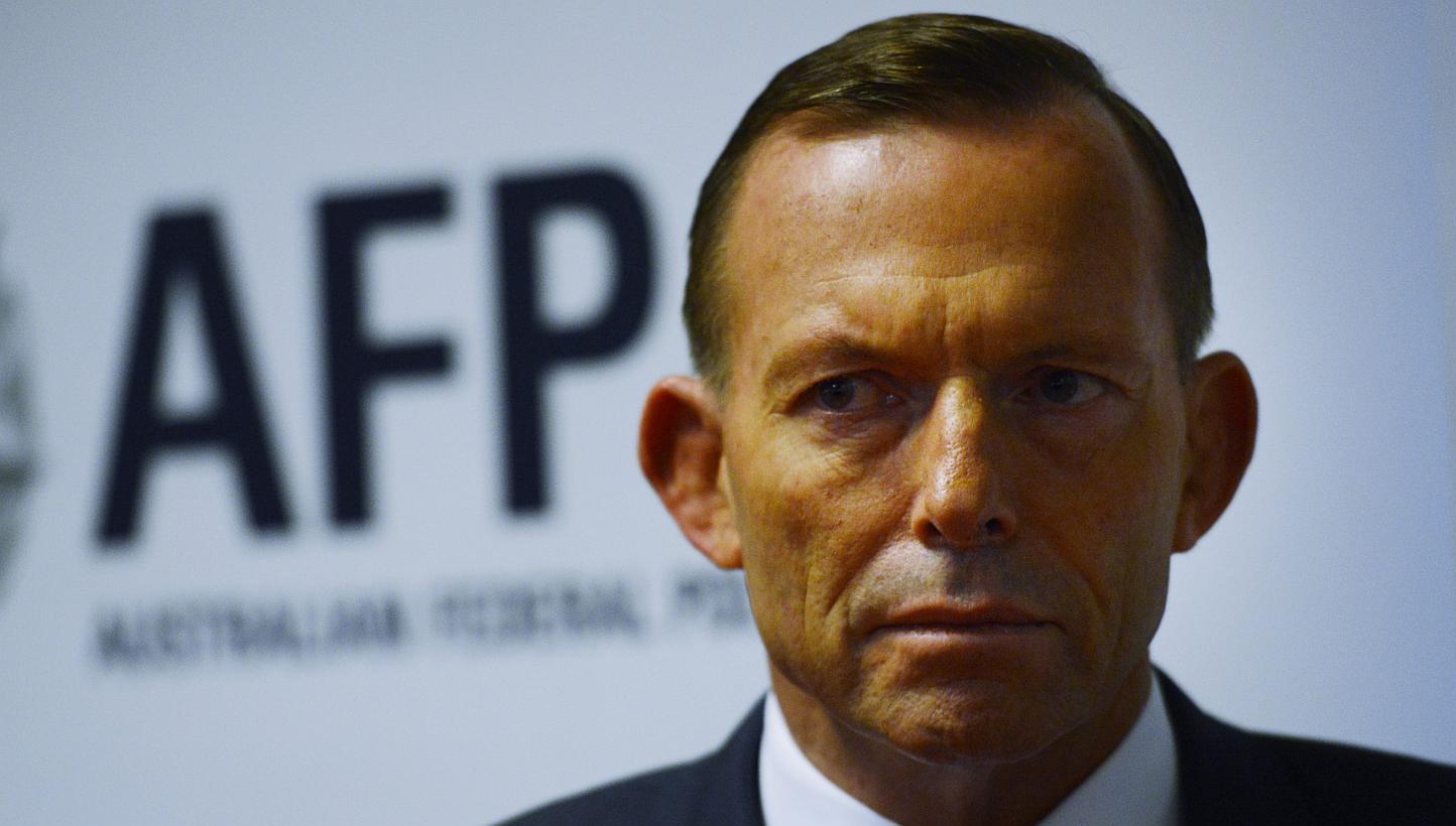 Australian Prime minister Tony Abbott looks on as he visits the Endeavour Hills police station in Melbourne, Australia, on June 12, 2015. Australian Prime Minister Tony Abbott did not deny the June 11, 2015 allegations that border officials paid peop
