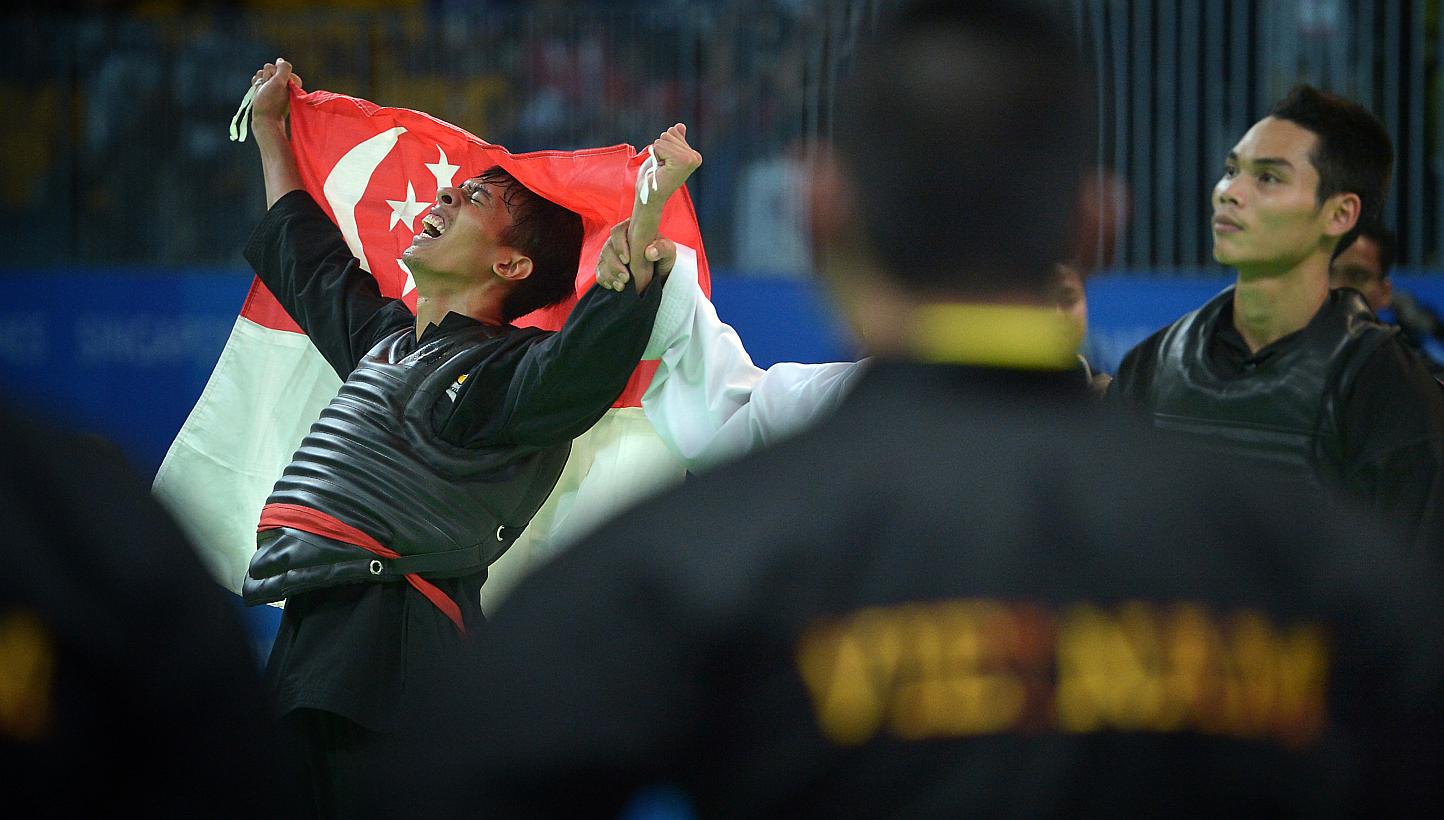Local silat exponent Muhammad Nur Alfian Juma'en celebrating his victory against Vietnam's world champion Tran Dinh Nam yesterday. Refusing to quit despite a bleeding foot, the 18-year-old clinched Singapore's 80th gold at the SEA Games. The Republic