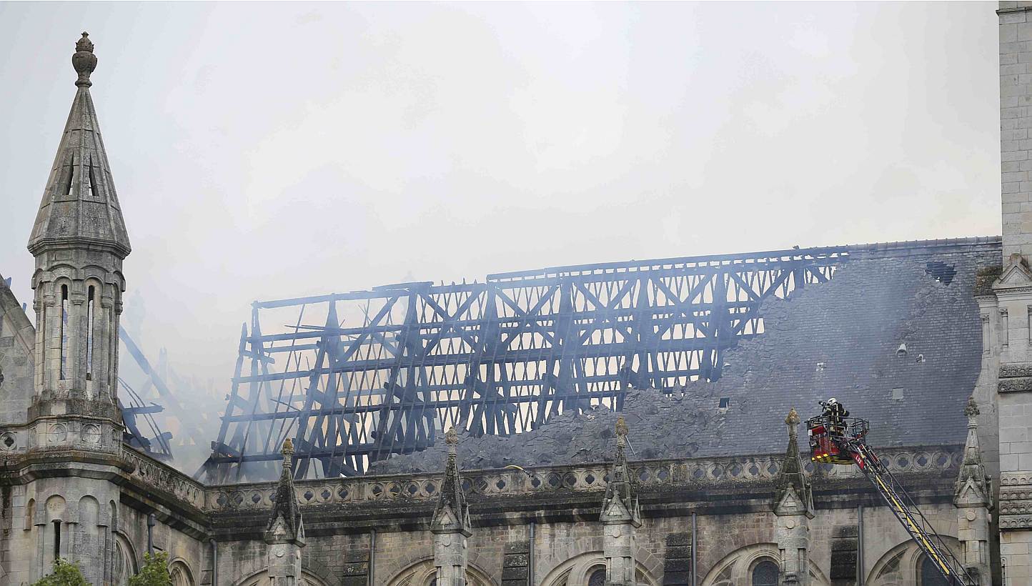 French firefighters try to extinguish the fire that damaged the roof of the Saint-Donatien Basilica in Nantes, western France on June 15, 2015. -- PHOTO: REUTERS