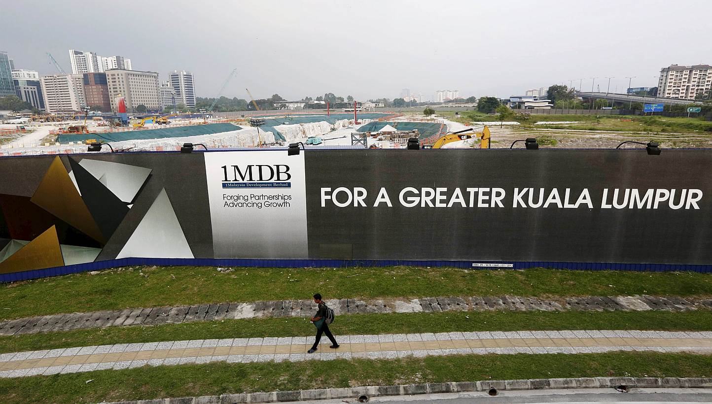 A man walks past a 1 Malaysia Development Berhad (1MDB) billboard at the funds flagship Tun Razak Exchange development in Kuala Lumpur, in this March 1, 2015 file photo. -- PHOTO: REUTERS