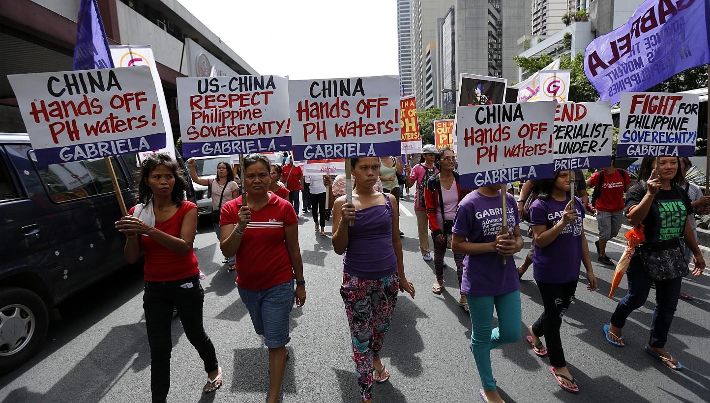 Filipinos display placards in protest over territorial disputes in the South China Sea during National Independence Day celebrations, in front of the Chinese consular office in Makati city, south of Manila, the Philippines, on June 12. -- PHOTO: EPA&
