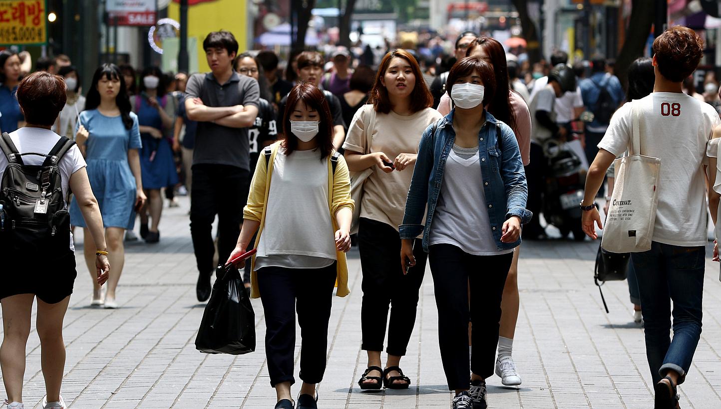 Pedestrians wearing masks walk through the Myeongdong shopping district of Seoul, South Korea, on Monday, June 15, 2015. -- PHOTO: BLOOMBERG&nbsp;