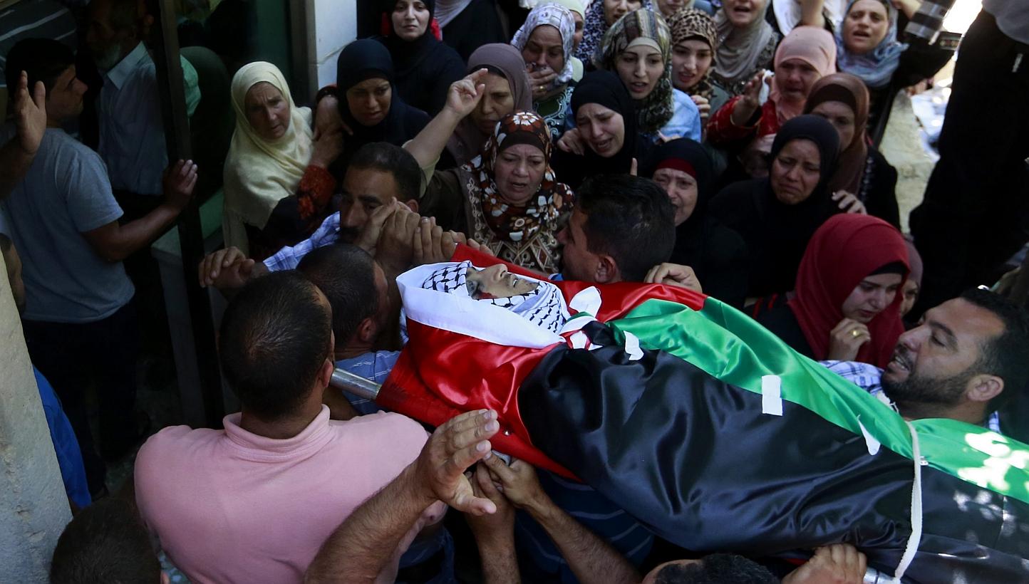 Palestinians carry the body of 21-year-old Abdallah Ghanayem, during his funeral in the west bank village of Qafr Malik near the West Bank city of Ramallah on Sunday. According to Palestinian medical sources, Israeli soldiers killed Ghanayem by hitti