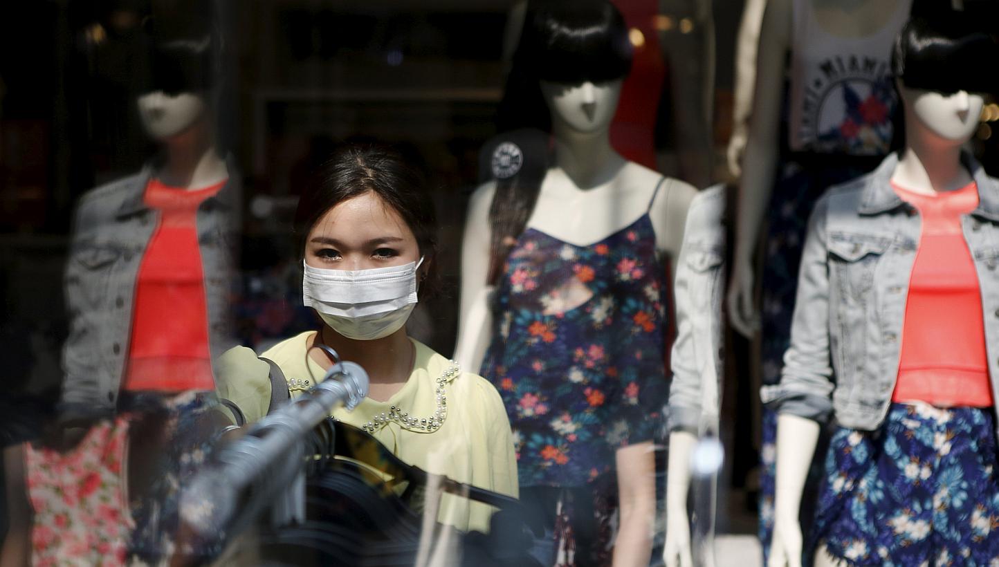 A woman wearing a mask to prevent contracting Middle East Respiratory Syndrome (MERS) shops at a clothing store in central Seoul, South Korea, on June 15, 2015. -- PHOTO: REUTERS