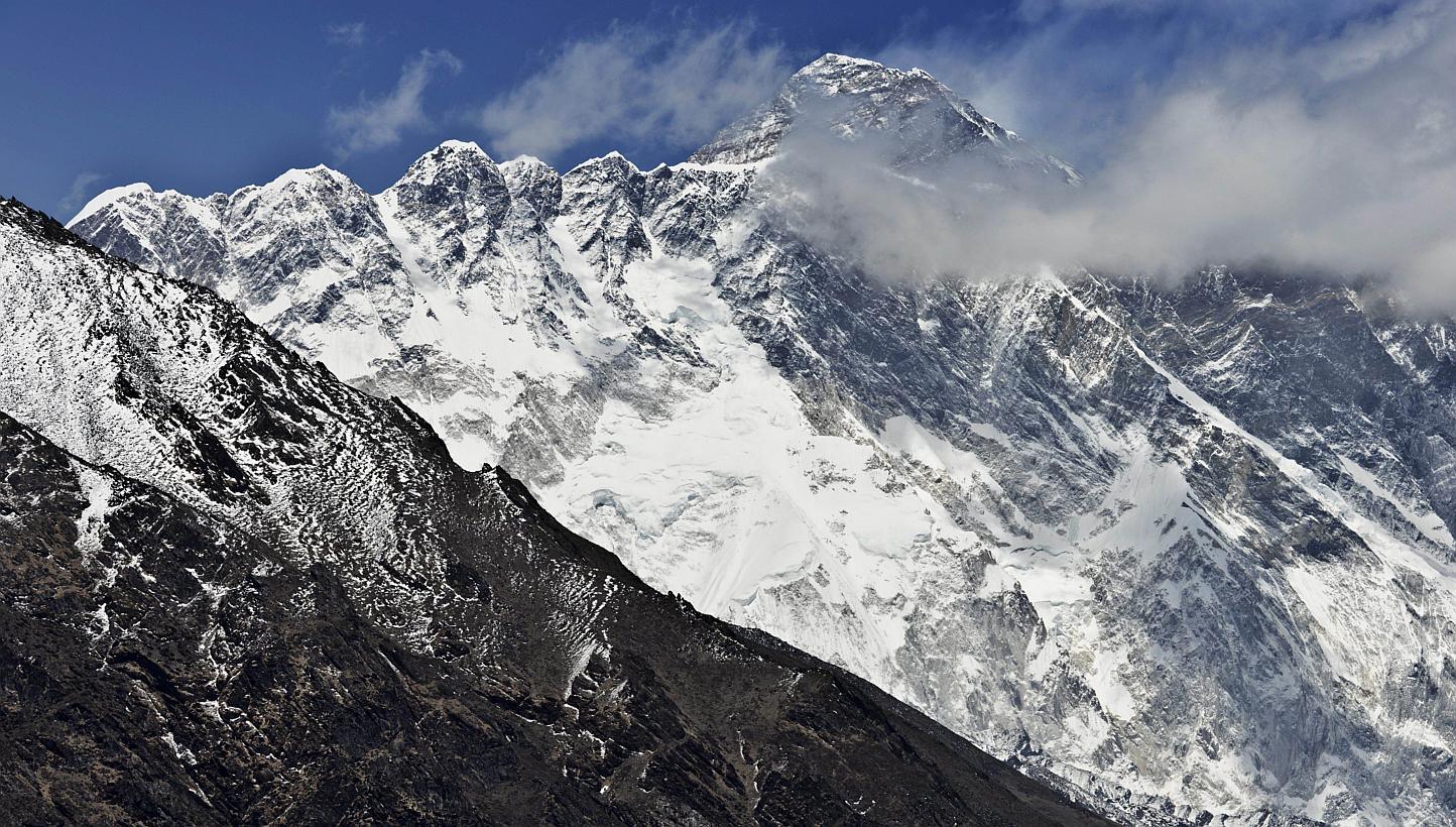 This photograph taken on April 20, 2015, shows a view of Mount Everest (centre, top) towering over the Nupse-Lohtse massif (foreground) from the village of Tembuche in the Khumbu region of northeastern Nepal. Mount Everest, moved three centimetres to