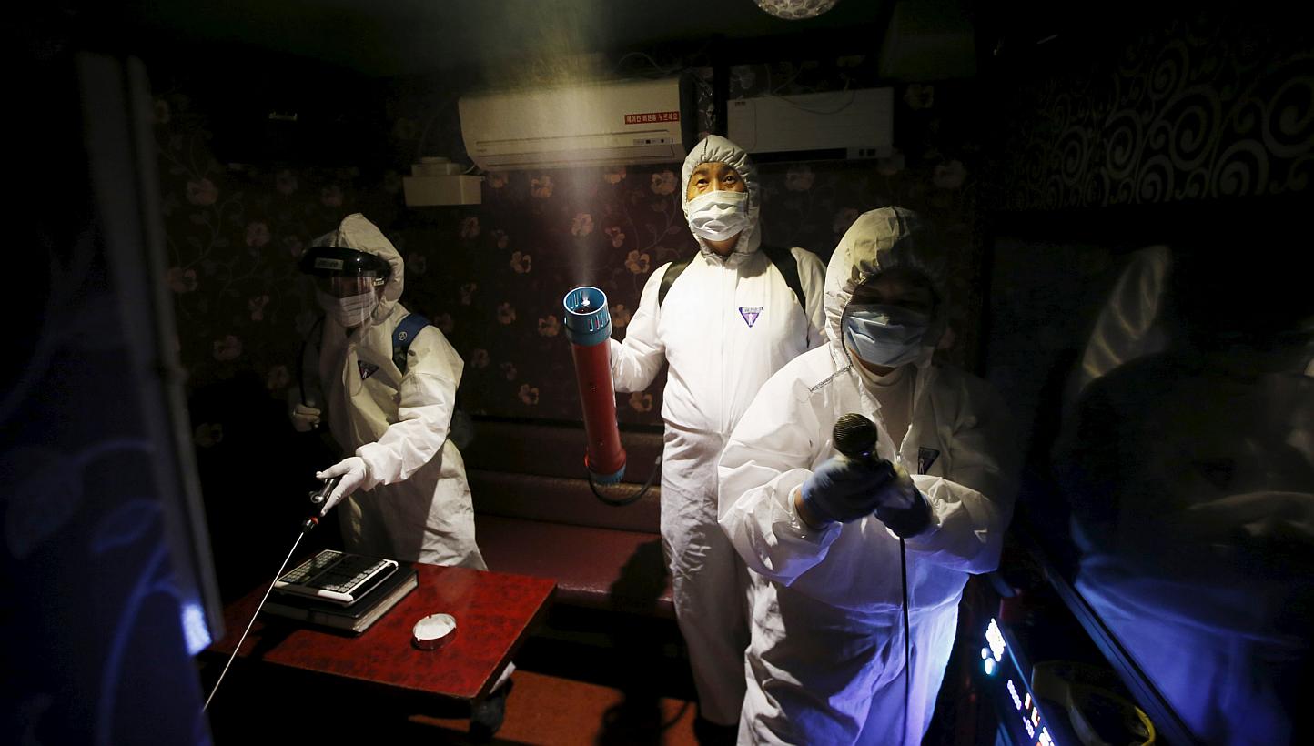 Workers disinfecting a karaoke establishment in Seoul, South Korea on June 16, 2015. Two South Korean hospitals are conducting experimental treatment on MERS patients, injecting them with blood plasma from recovering patients. -- PHOTO: REUTERS 