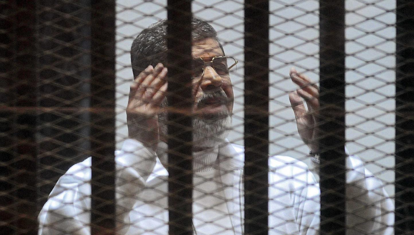 Former Egyptian president Mohamed Mursi gesturing in a cage in the courtroom where he stands charged of spying with Qatar, in Cairo, Egypt, on Feb 15, 2015. An Egyptian court sentenced Mursi to death on Tuesday, June 16, in a case related to a 2011 m
