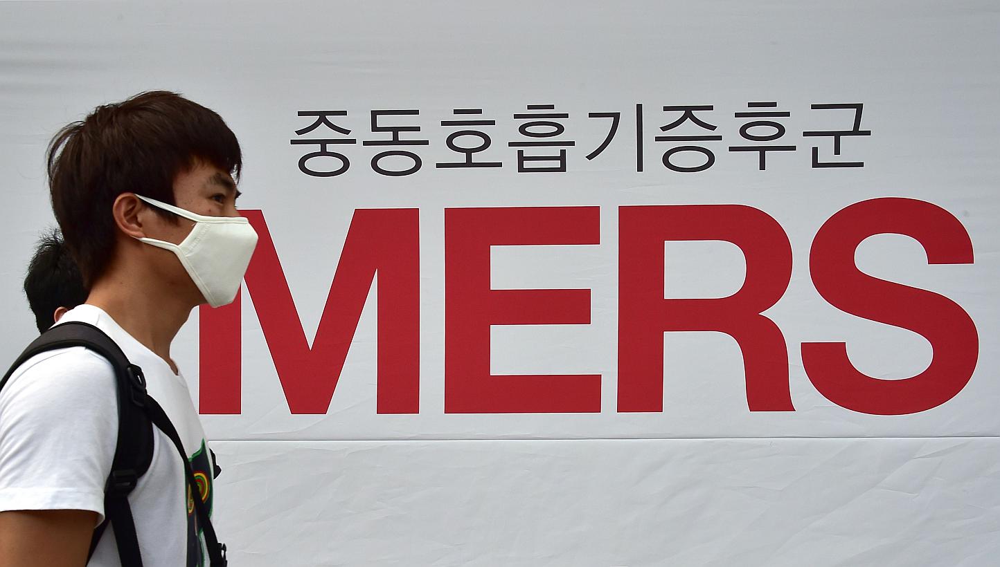 A man wearing a face mask walks past signage on the Middle East Respiratory Syndrome (Mers)&nbsp;at Severance Hospital in Seoul on June 16, 2015. A hospital in Prague, in the Czech Republic, admitted a patient who may have contracted the Mers virus, 
