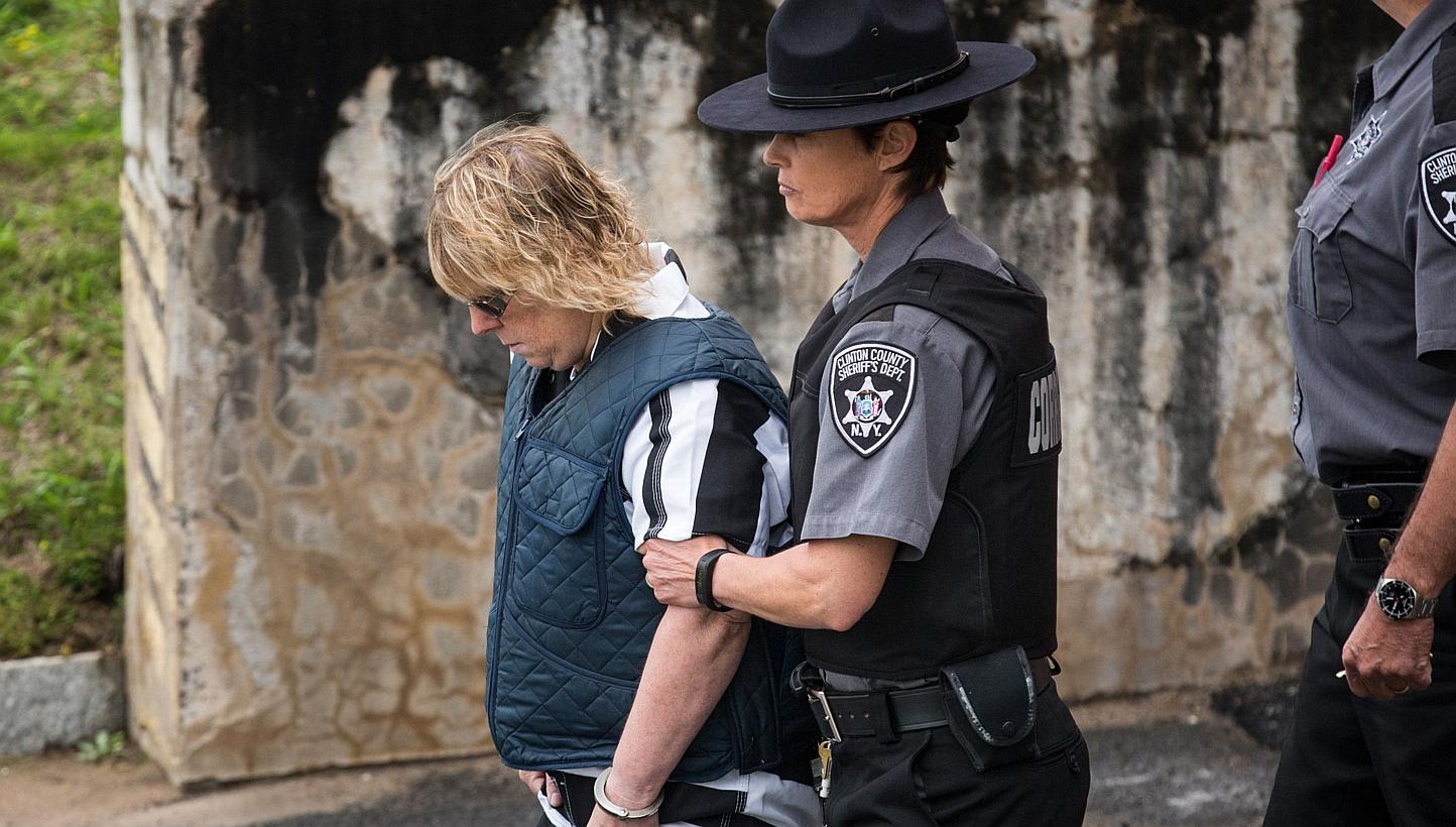 Joyce Mitchell (left), a prison worker who allegedly helped two convicts escape from prison, is lead from Plattsburgh Ciy Court after a hearing on Monday in Plattsburgh, New York. -- PHOTO: AFP